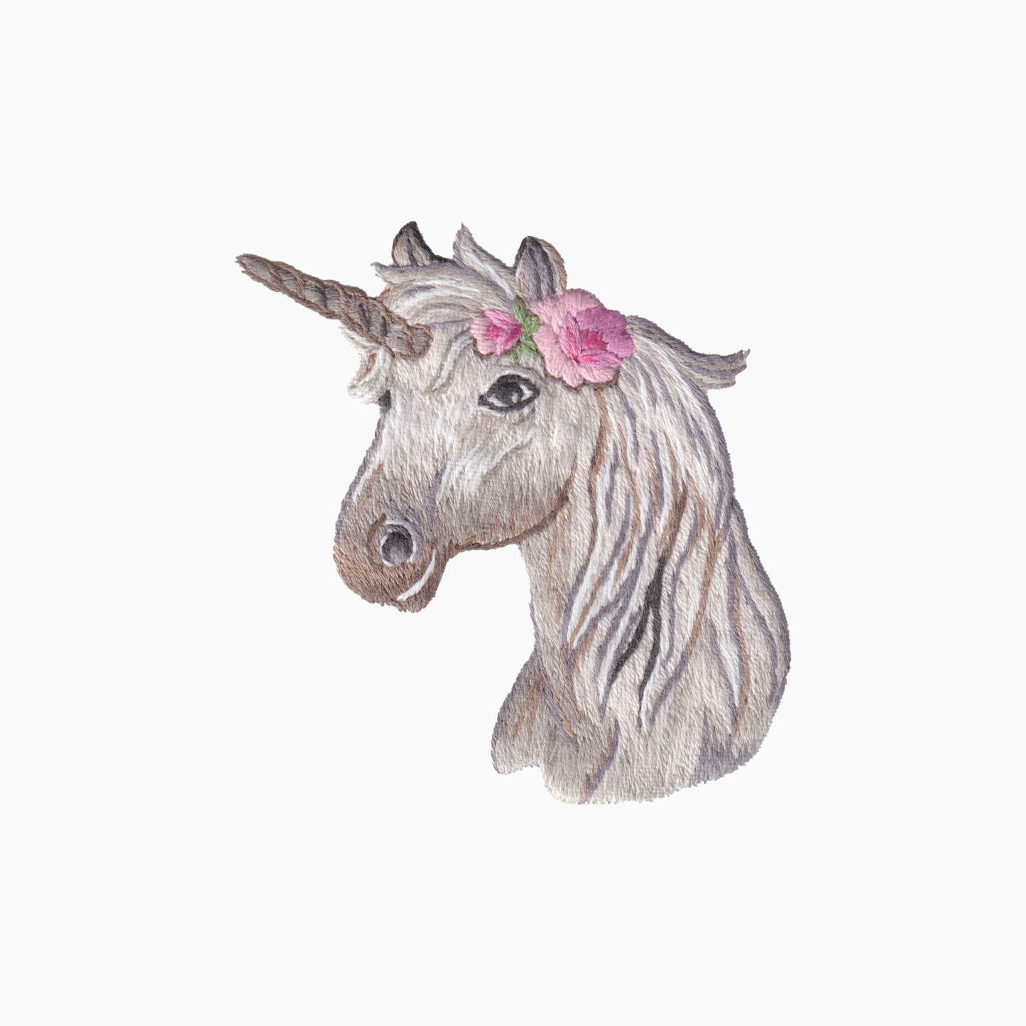 Hand embroidered cotton towel of a unicorn head with a flower on a white background