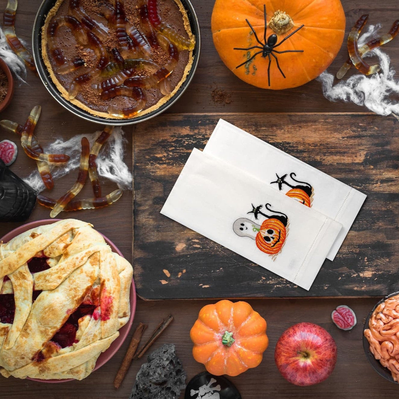 Halloween-themed pies and decorations on a wooden table