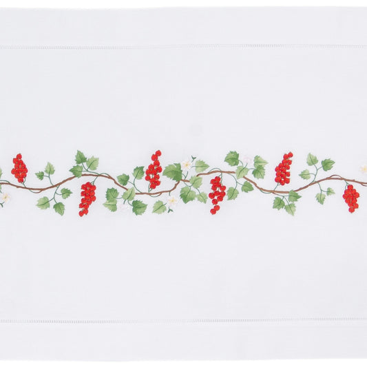 A white table runner with a hemstitch border. A vine of currents is embroidered in a line down the middle.
