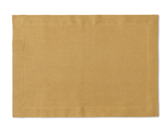 A linen placemat in the color curry
