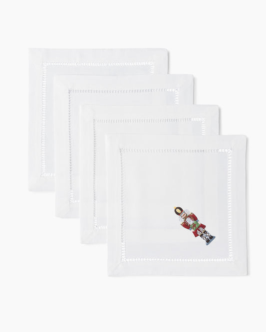 Four white Nutcracker Cocktail Napkin Sets with Henry Handwork on them.