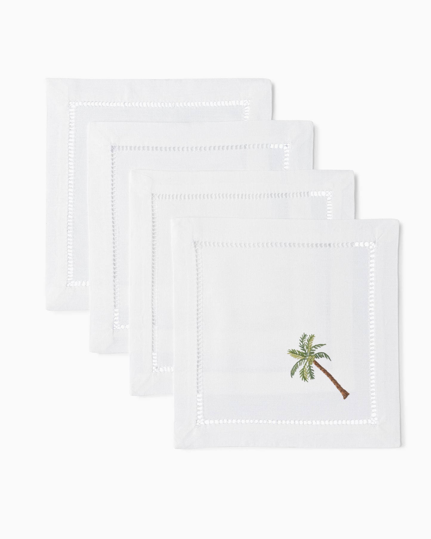 Four white Palm Tree Modern Cocktail Napkin Sets by Henry Handwork with palm trees on them.