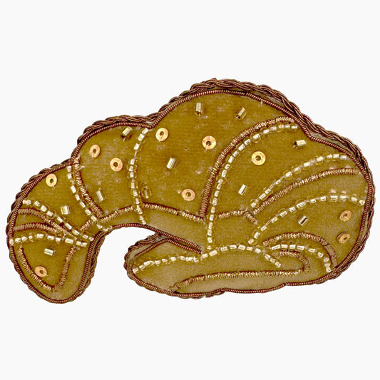 Image of a croissant Christmas ornament with intricate beadwork.