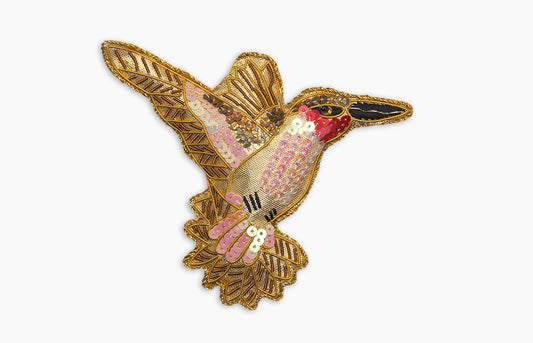 Image of a pink hummingbird Christmas ornament with intricate beadwork. 