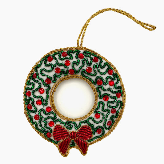 Image of a red berry and snowy wreath Christmas ornament with intricate beadwork. 