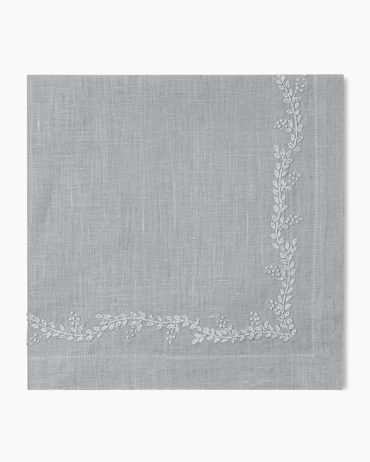 A Prism Vine Linen Dinner Napkin - 13 Colors by Henry Handwork with white embroidery, perfect for table linens.