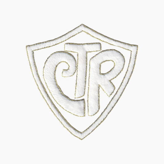 Hand embroidered cotton towel of logo with initials 'CTR' on a shield shape background