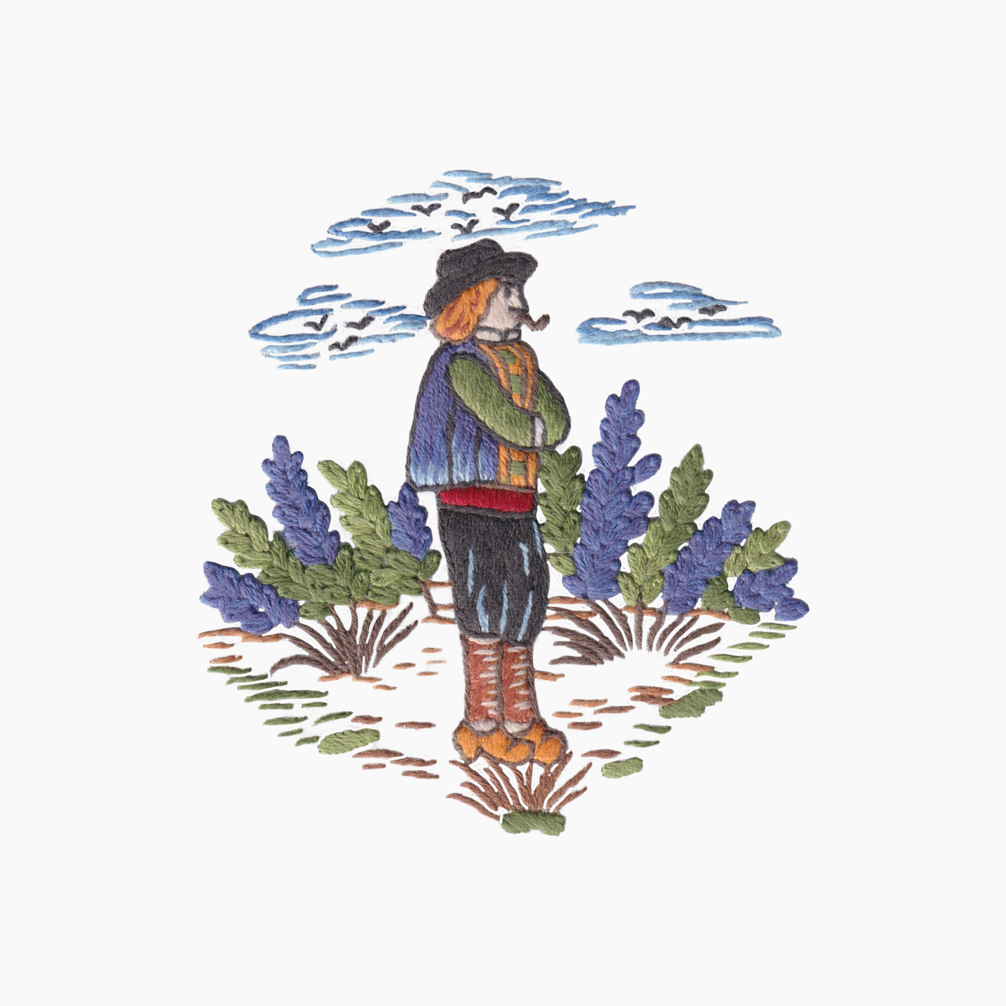 Hand embroidered cotton towel with  design of a Quimper style man standing in a field with lavender and birds in the sky.