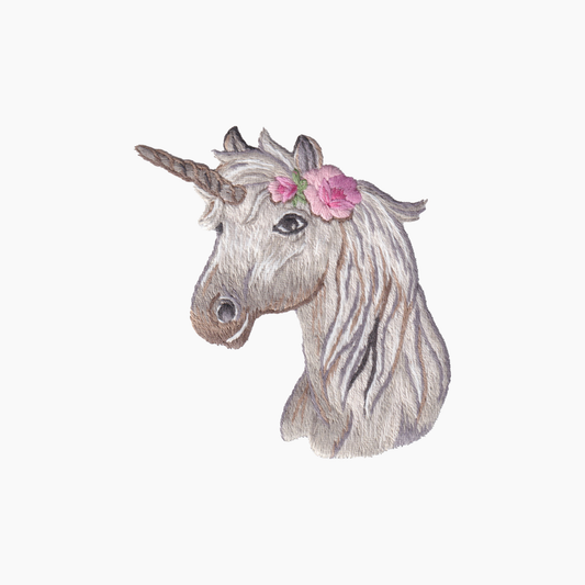 Hand embroidered cotton towel of a unicorn head with a flower on a white background