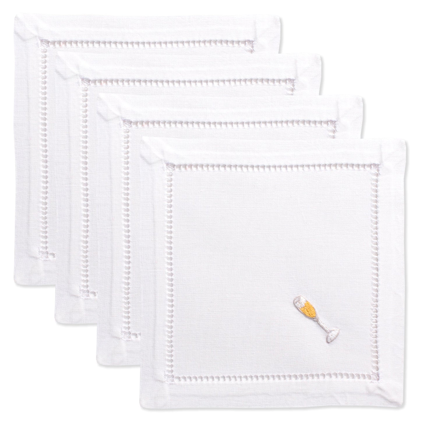 4 white cocktail napkins. Embroidered in the bottom right corner of each is a filled champagne glass.