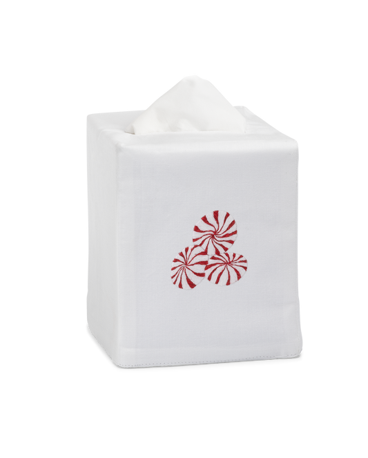 A white tissue cover with three peppermint candies embroidered in the center.