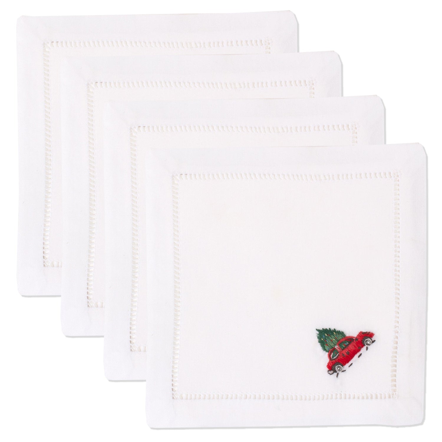 4 white cocktail napkins. Embroidered in the bottom right corner of each is a red car with a christmas tree tied on top.