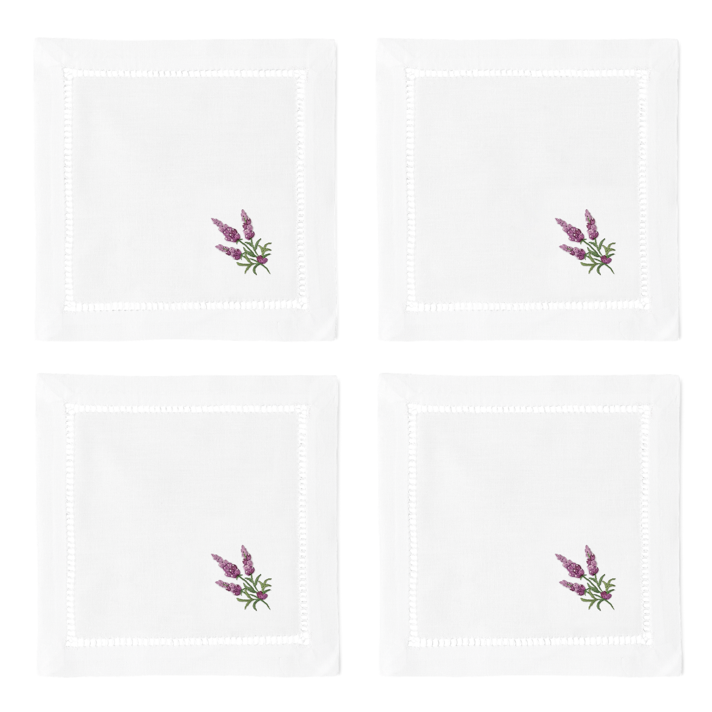 4 white cocktail napkins. Embroidered in the bottom right corner of each is a bundle of lavender