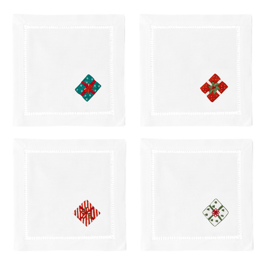 4 white cocktail napkins with a hemstitch border. A different wrapped gift is embroidered on the bottom right corner of each