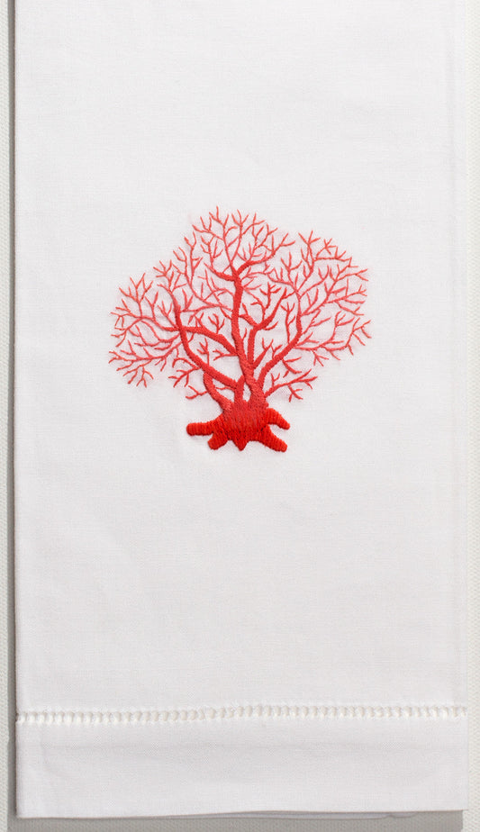 A white hand towel with a hemstitch. A piece of red coral is embroidered in the center.