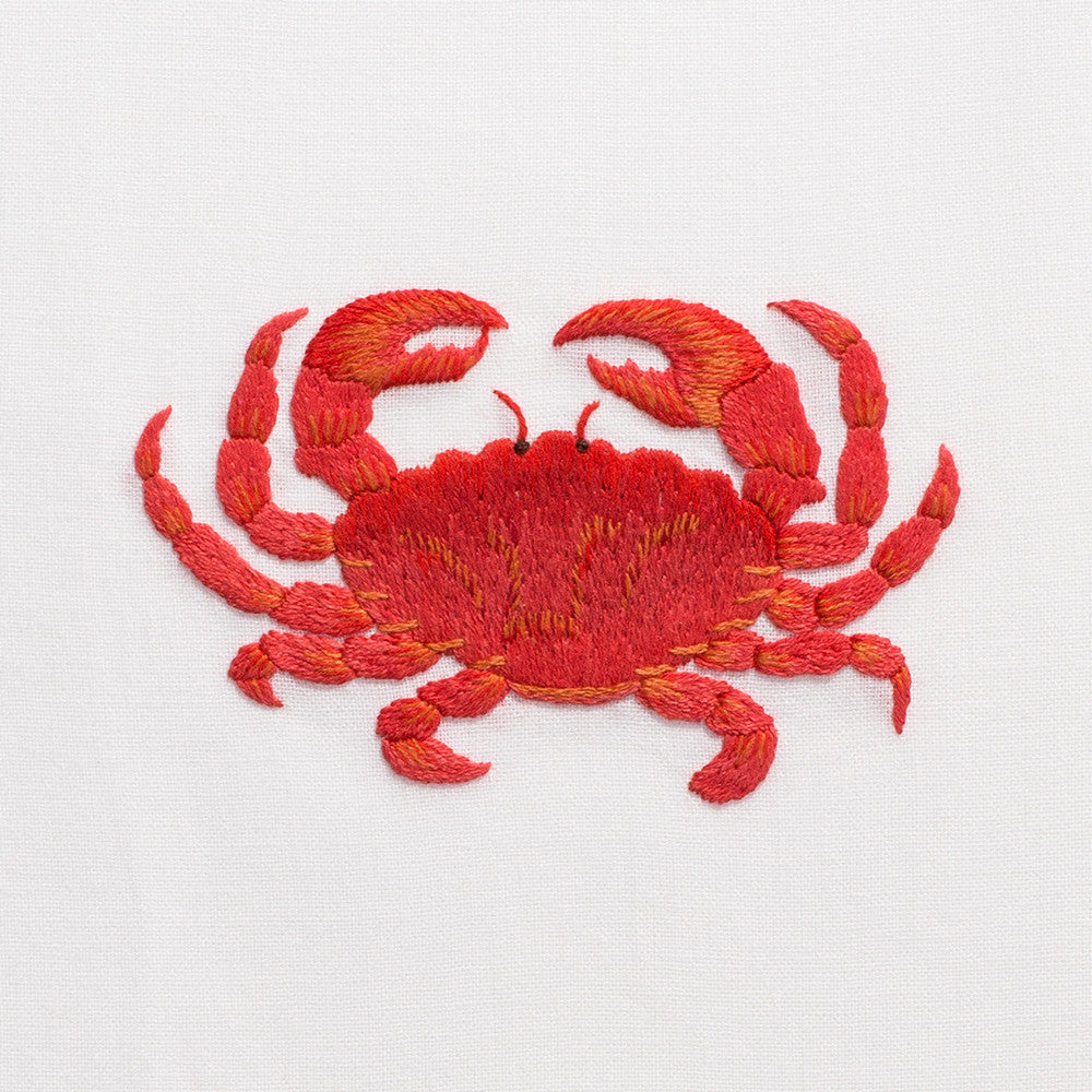 A close up detailed image of the embroidery - A red crab in birds eye view.