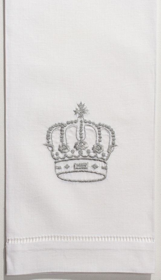A white hand towel with a hemstitch. A silver crown embroidered in the center