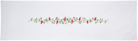A white table runner with a hemstitch border. A vine of currents is embroidered in a line down the middle.