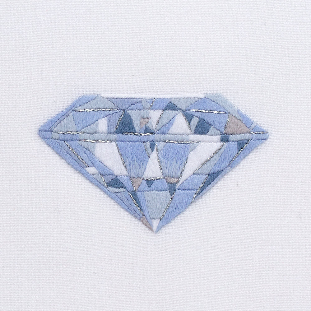 A close up detailed image of the embroidery - A blue and white silvery diamond