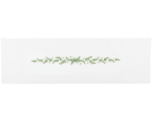 A white runner with a hemstitch border. Curling fern fronds are embroidered in a line down the center.