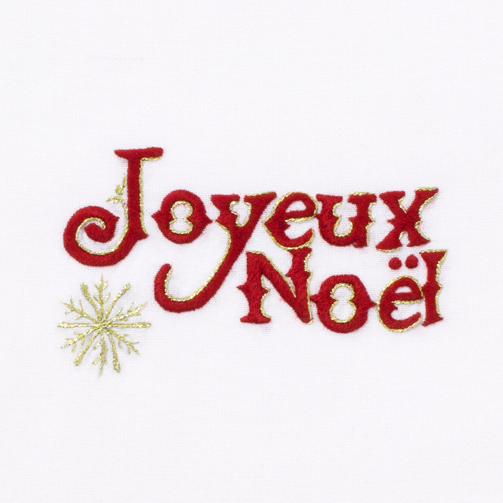A detailed image of the embroidery - Red text with gold borders saying “Joyeux Noel” and a gold snowflake