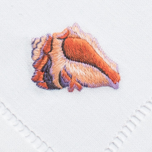 an embroidered conch shell in the blush color