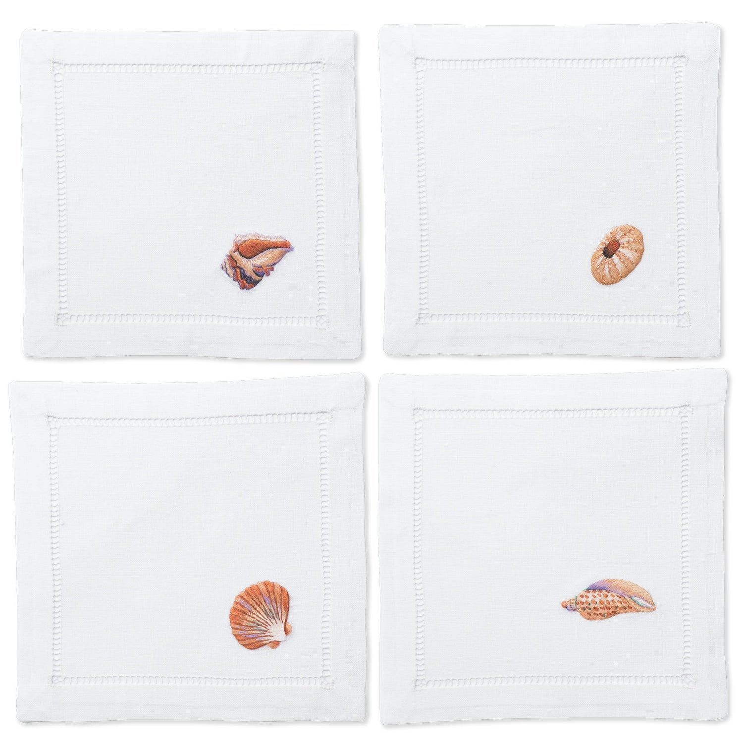 4 white cocktail napkins with a hemstitch border. Embroidered on the bottom right corner of each is a different blush colored shell