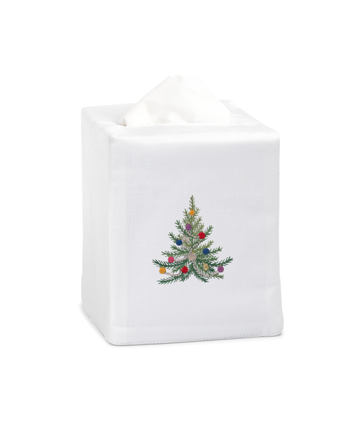 A white tissue cover with a green christmas tree with glittery ornaments in the center.