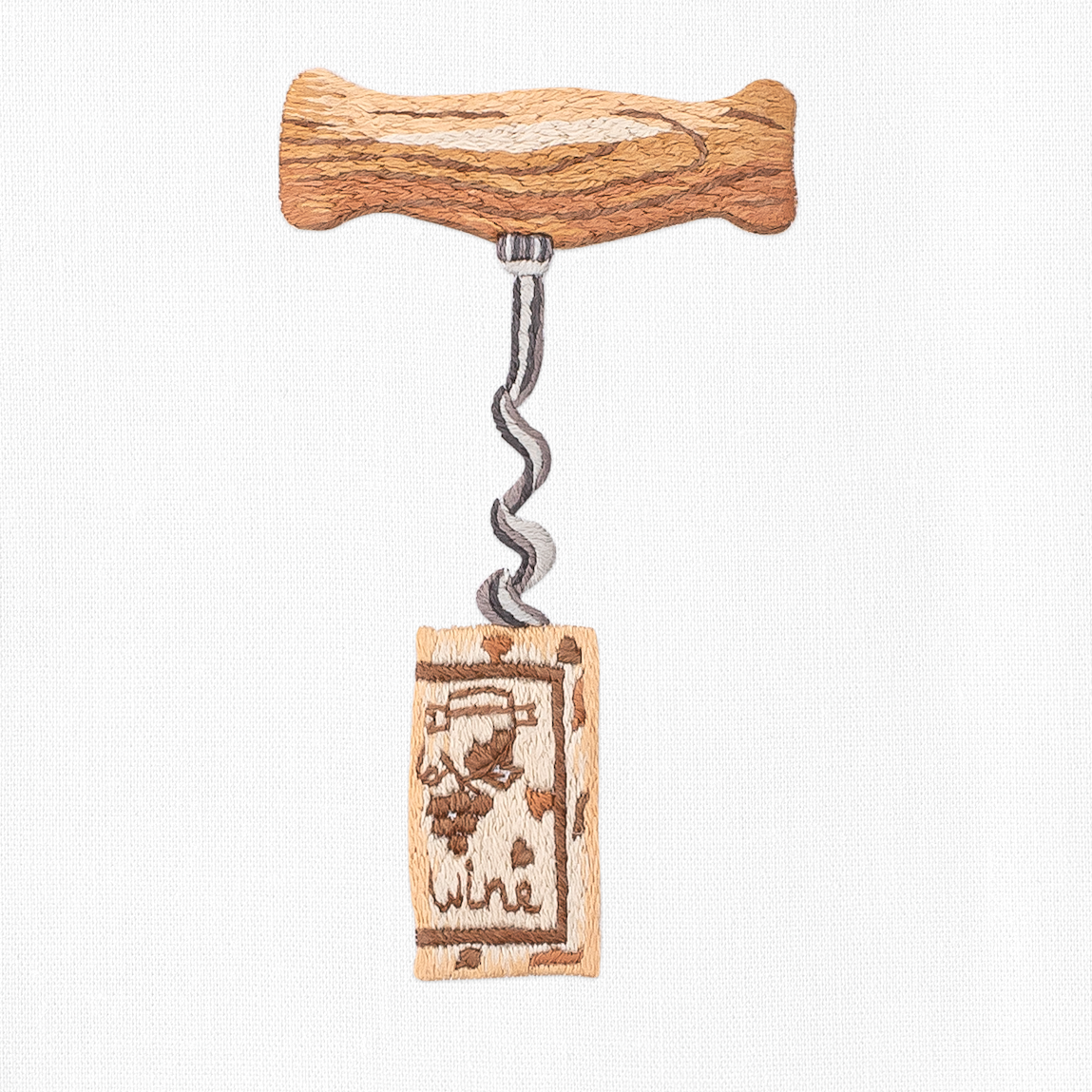 A close up detailed image of the embroidery - A silver corkscrew with a wooden handle twisted into a wine cork.