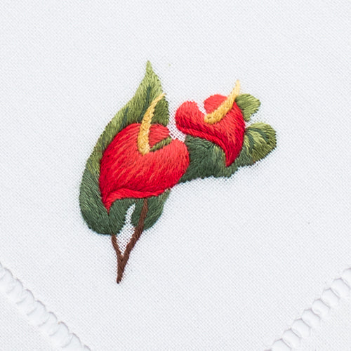 two embroidered red anthurium flowers with green leaves